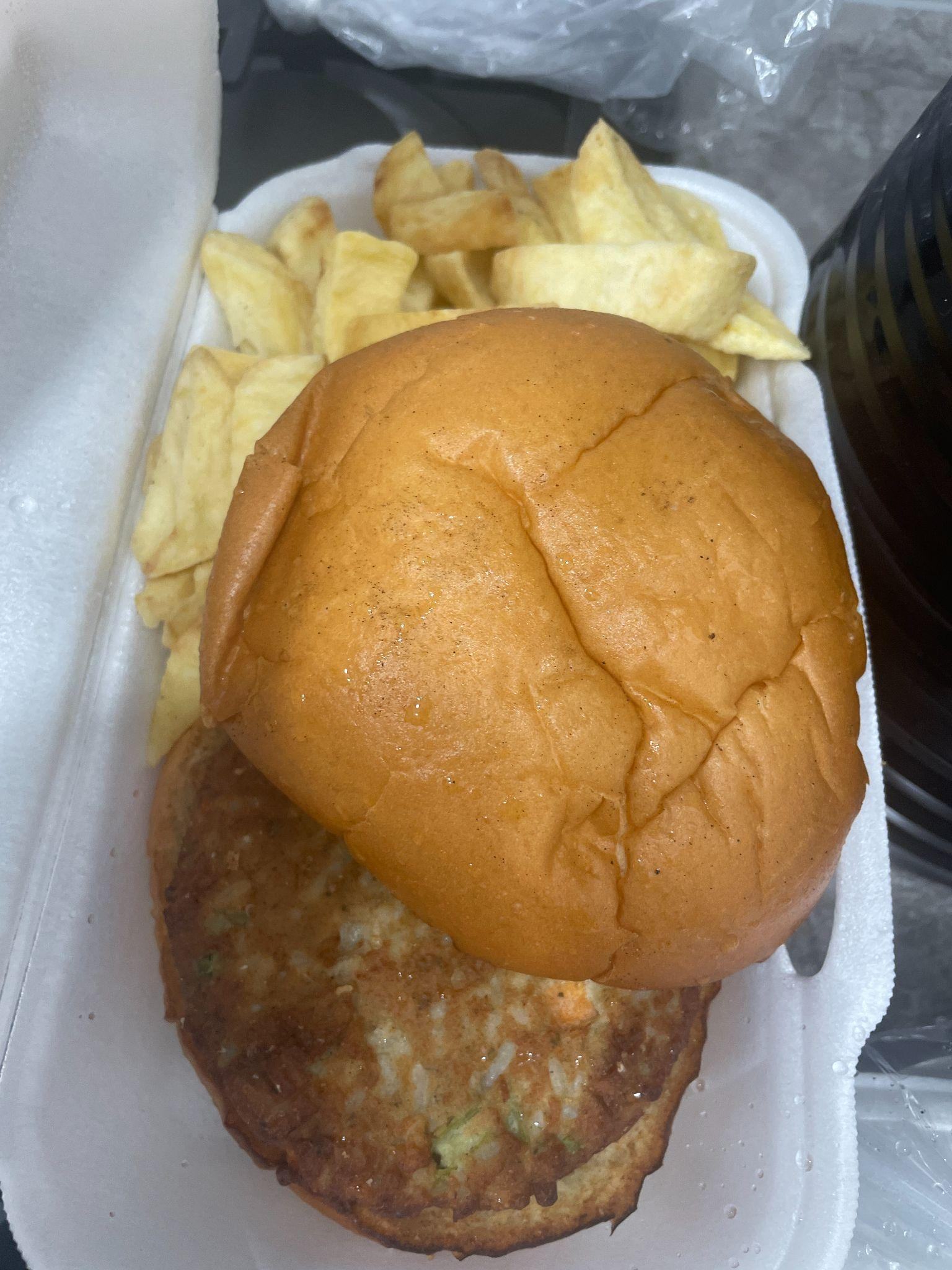 A white styrofoam container holding a burger and chips, representing a food item analyzed in the report.