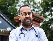 Headshot of a smiling man with glasses, beard, and stethoscope, wearing a light blue shirt, suggesting a medical professional.