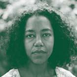 Portrait photo of a woman with dark curly hair looking directly forward.