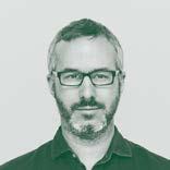 Headshot of a smiling man with a beard and glasses