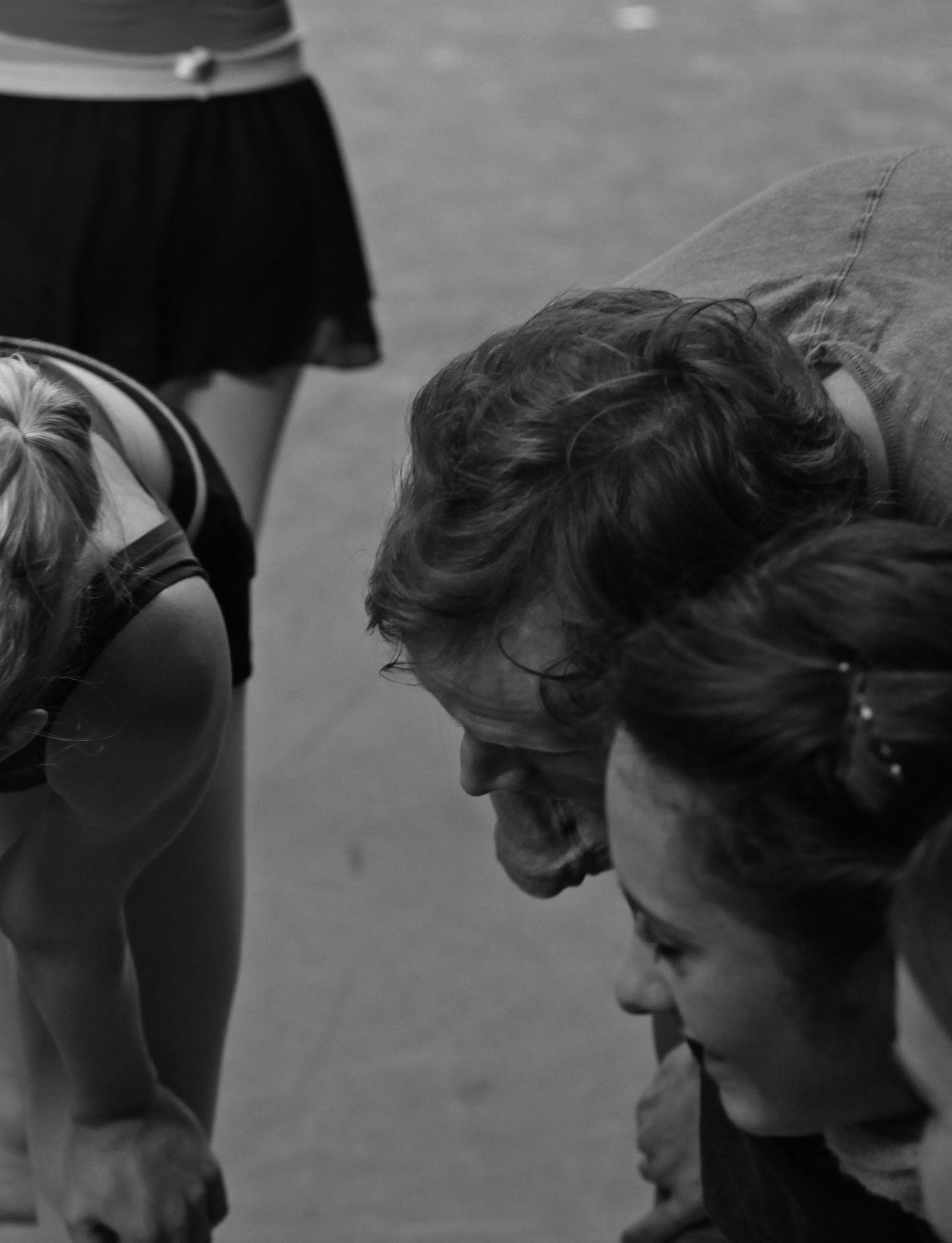 Group of individuals looking intently at something below them, suggesting collaboration or instruction.
