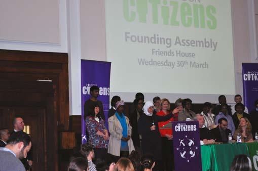 Attendees at the London Citizens Founding Assembly, with event details projected on a screen.
