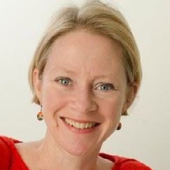 Headshot of a woman with short blonde hair, wearing a red top, smiling.