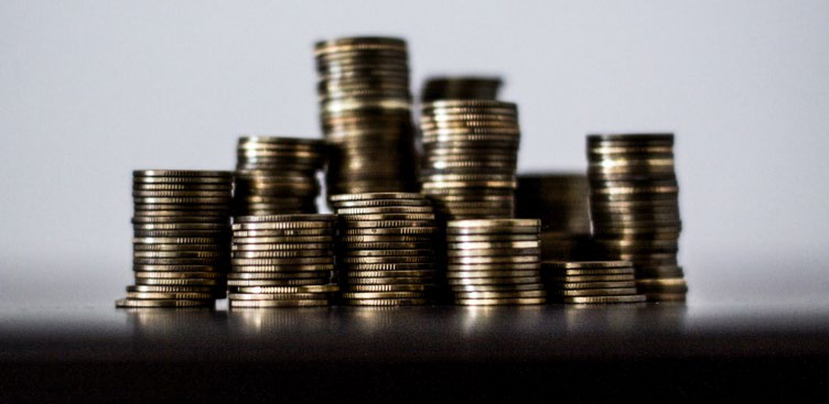 Various stacks of gold coins of different heights, symbolizing finance, wealth, or investment.