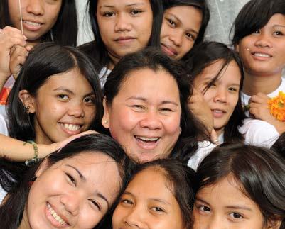 Group of diverse women and girls smiling warmly, representing community or beneficiaries of a program.