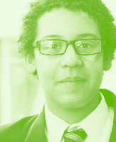Close-up portrait of a young person wearing glasses and a uniform-style shirt and tie, rendered in a green monochromatic filter.