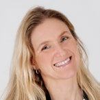 Headshot of a smiling woman with long blonde hair, possibly a staff member or featured individual.