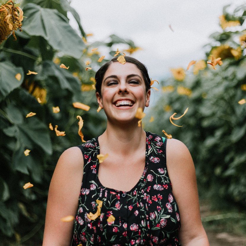 Woman walks through sunflower field